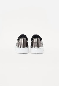 Μεταλλικά γκρι παπούτσια slip-on με μαύρο ελαστικό κολάρο, λευκή πλατφόρμα και λογότυπο DKNY στη φτέρνα. Λείος υφής και κομψό σχέδιο.