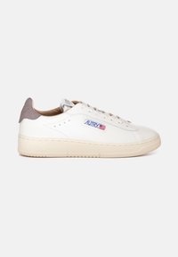 Sneaker bianche in pelle con una suola intermedia beige, una linguetta in suede grigia e dettagli perforati. Presentano lacci e un'etichetta con logo sul lato.