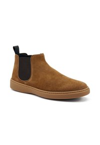 Bottines Chelsea en daim marron avec un panneau latéral flexible et une semelle en caoutchouc contrastante, présentées sur un fond blanc.