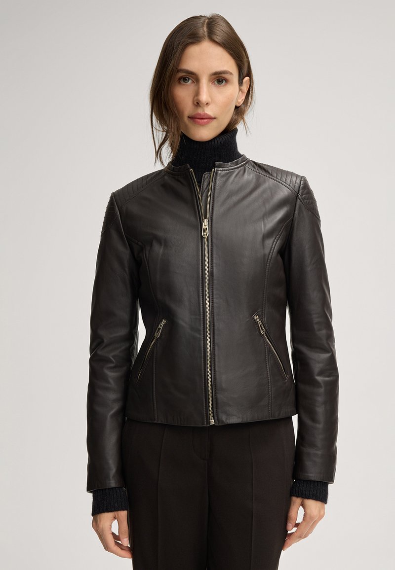 Schwarze Lederjacke mit einer figurschmeichelnden Passform, Reißverschluss auf der Vorderseite, gesteppte Schulterakzente und zwei Reißverschlusstaschen an den Seiten. Strukturiertes Ärmeldesign.