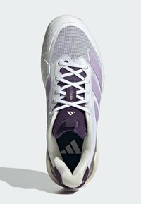 Baskets blanches avec des accents violets, tige en mesh, col rembourré et semelle contrastante. Présente un logo bien visible sur la languette.