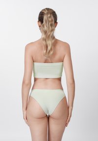 Mentaszínű bikini szett pánt nélküli felsőrésszel és alacsony derekú alsóval, bordázott anyagból, sima textúrával és minimális varrással.