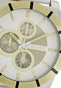Montre en acier inoxydable argent et or avec un cadran blanc texturé, trois petits sous-cadrans et des index horaires audacieux. Caractéristique d'un boîtier rond en acier inoxydable.