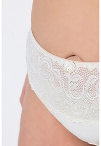 Witte kanten slip met ingewikkelde bloemenpatronen, zachte stof, geschulpte randen en een kleine decoratieve knoopaccent.