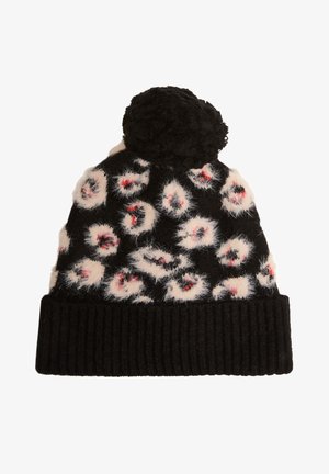 Zwarte gebreide beanie met pompon. Heeft pluizige witte en rode luipaardvlekken aan de bovenkant, met een gestructureerde zwarte geribbelde manchet aan de onderkant.