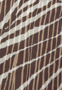 Stoff mit einem welligen, gestreiften Muster in Brauntönen, Creme und Beige. Die Textur wirkt gewebt und hat eine weiche Oberfläche.