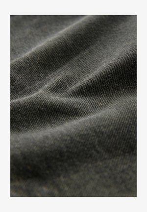 Tessuto in denim grigio scuro che mostra una superficie morbida e strutturata con linee e pieghe sottili, che indicano flessibilità e profondità nel materiale.