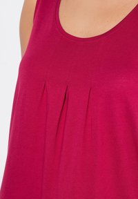 Fuchsia ärmelloses Top mit Rundhalsausschnitt, das an der Vorderseite Falten für Textur und Detail aufweist, aus einem weichen, glatten Stoff gefertigt.