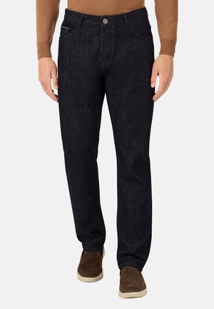 Dunkelblaue Denim-Jeans mit geradem Schnitt, Fronttaschen und einem Metallknopfverschluss, kombiniert mit braunen Wildlederschuhen.