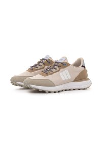 Beige und hellbraune Laufschuhe mit einer Mischung aus glatten und strukturierten Materialien. Weißes Logo an der Seite, gemusterte Schnürsenkel und eine robuste Außensohle.