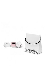 Sac de shopping blanc avec une poignée noire et "PANDORA" imprimé, à côté de deux petites boîtes à bijoux blanches avec des intérieurs roses, dont l'une est ouverte.