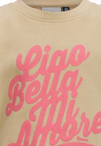 Felpa beige con testo rosa che recita "Ciao Bella" in un font oversize e testurizzato. Presenta un collare a coste e un tessuto morbido.