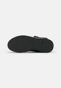 Talpa de sneaker neagră cu un fund din cauciuc texturat, având un model de linii orizontale și verticale, care îmbunătățește aderența și durabilitatea.
