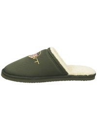 Green fabric slipper with a soft cream interior lining, featuring a shield logo and textured surface. Slip-on design, round toe.