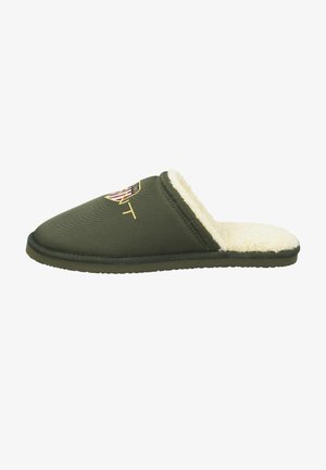 Green fabric slipper with a soft cream interior lining, featuring a shield logo and textured surface. Slip-on design, round toe.