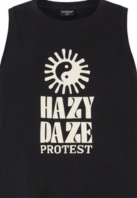 Top negro sin mangas hecho de algodón, con un gráfico de un sol blanco y el símbolo yin-yang, acompañado del texto "HAZY DAZE PROTEST" en letras gruesas y estilizadas.