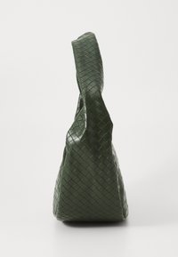 Woven green leather handbag with a textured surface, featuring a wide, rounded handle and a triangular, flat base for stability.