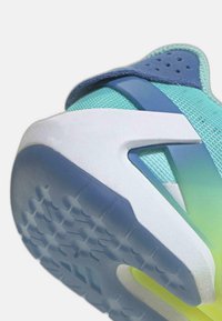 Baskets aqua et bleues avec tige en mesh texturé, semelle en caoutchouc blanche et accents vert clair ; présentent un design unique du contrefort du talon.