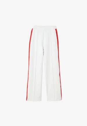 Białe spodnie o szerokich nogawkach z plisowanym przodem, z czerwonymi paskami po bokach i elastycznym stanem. Gładka tekstura, brak widocznych elementów metalowych.