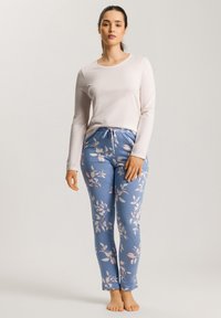 Camiseta de manga larga color rosa claro combinada con pantalones jogger de estampado floral azul que cuentan con una cinturilla elástica y detalles de cordón.