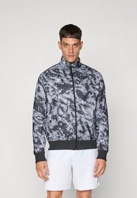 Herreur med lynlås i sort og gråt digitalt camouflagemønster, letvægtsstof, høj hals, elastiske manchetter og linning.