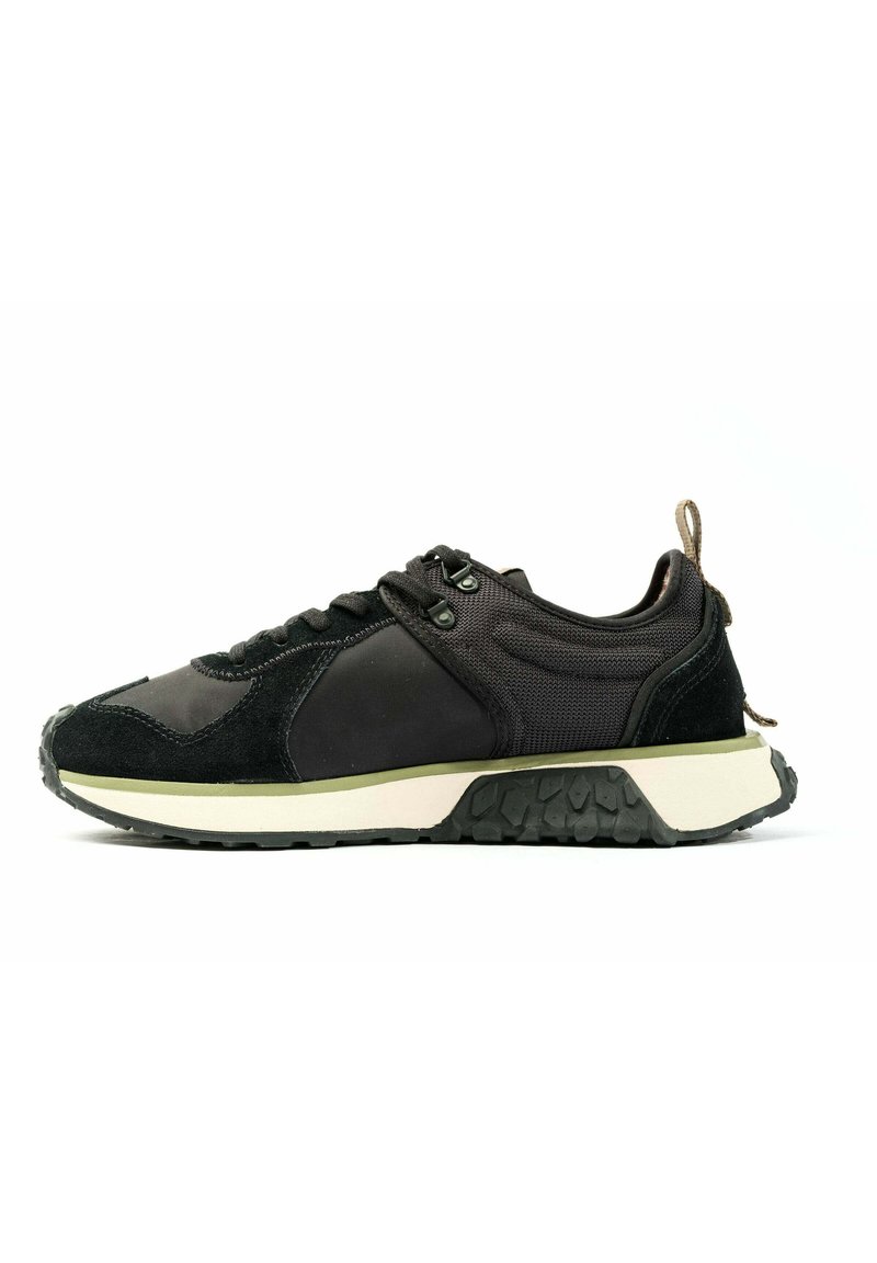 Scarpa atletica nera con una combinazione di materiali lisci e testurizzati, dotata di suola in gomma, design con lacci e una linguetta sul tallone.