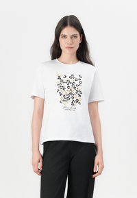 Bela bomba iz bombažastega materiala s kratkimi rokavi, ki ima leopardji motiv v črnih in zlatih tonih, z black besedno frazo spodaj.
