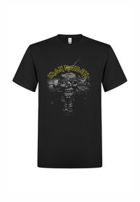 Camiseta de algodón negra con un gráfico de una calavera y elementos mecánicos con el texto "Iron Maiden" en amarillo sobre el diseño.