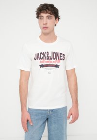 Λευκό βαμβακερό T-shirt με το γράφημα "JACK&JONES" σε κόκκινο και ναυτικό μπλε, στρογγυλή λαιμόκοψη, κοντά μανίκια και άνετη γραμμή.