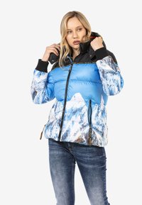 Gepolsterte Jacke mit blauem oberen Teil, weißem Bergdruck am unteren Ende und einer schwarzen Kapuze. Inklusive Reißverschluss und gerippten Bündchen.