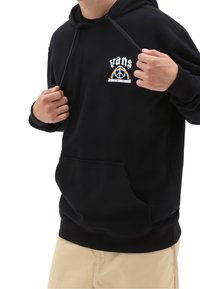 Sudadera con capucha negra hecha de tela suave, con un bolsillo frontal y un diseño de logotipo bordado con acentos coloridos.