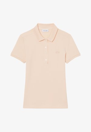 Licht perzikkleurig polohemd met korte mouwen, kraag, vier witte knopen en klein geborduurd krokodillenlogo op de linkerborst.
