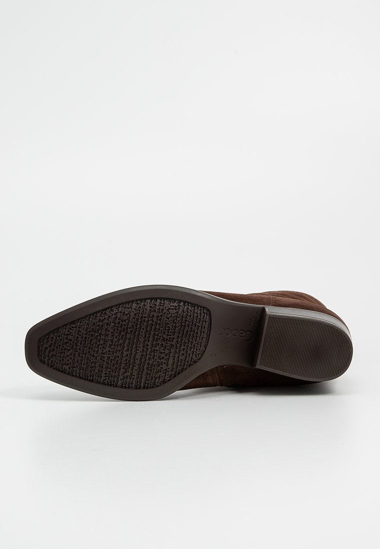 Braune Wildleder-Stiefelette mit einer strukturierten Gummisohle, runder Zehenpartie und niedrigem Absatz. Das Design ist schlank und mit minimalen Akzenten gehalten.