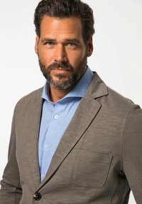 Blazer grigio con una tasca sul petto, abbinato a una camicia azzurro chiaro in tessuto strutturato con colletto alla bell' italiana.
