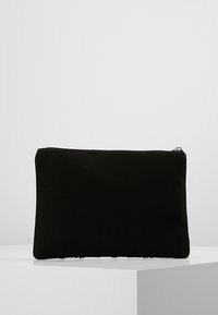 Pochette en tissu noir dotée d'une texture lisse et d'un design simple. Fermeture zippée en haut. Style minimaliste sans ornement.