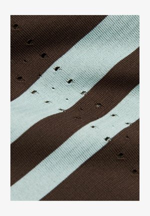 Strikket stof med skiftevis brune og lyseblå striber, der viser flere små huller og slidte områder over hele overfladen.