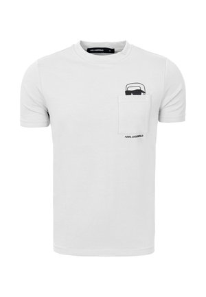 Biała koszulka z krótkim rękawem z kieszenią na piersi, ozdobiona czarną grafiką przedstawiającą twarz Karla Lagerfelda w okularach przeciwsłonecznych nad nazwą marki.