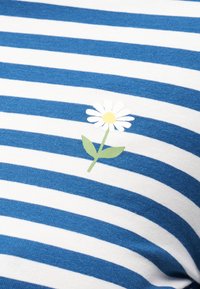 Ύφασμα με μπλε και λευκές ρίγες, στο οποίο είναι τυπωμένο ένα μικρό λευκό μαργαριτάρι με κίτρινο κέντρο και πράσινο μίσχο.