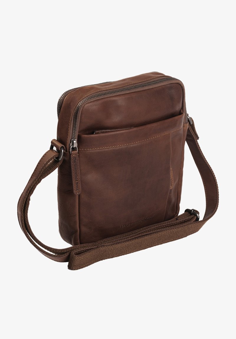 Borsa a tracolla in pelle marrone con chiusura a zip, tasca frontale e tracolla in tessuto regolabile. Texture morbida con dettagli di cucitura discreti.