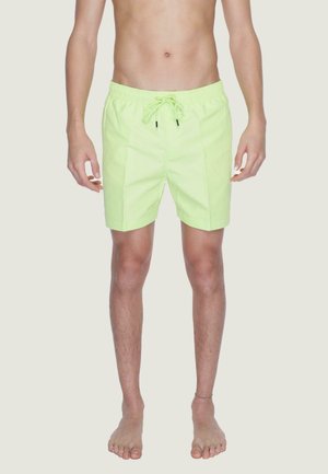 Costumi da bagno verde neon realizzati in tessuto leggero, con vita elastica e cordino, e vestibilità rilassata.