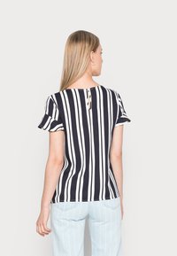 Blusa de manga curta às riscas azul marinho e branca com decote redondo e detalhe de abertura nas costas, feita de um tecido suave.