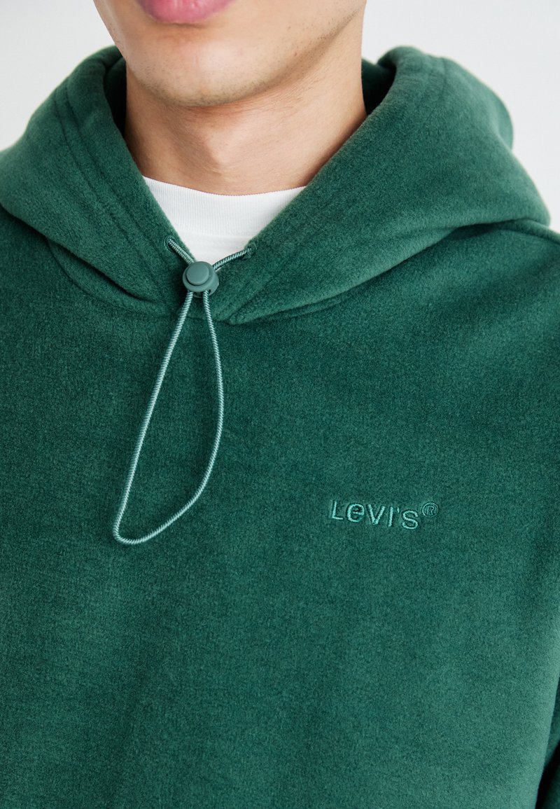 Grüne Fleece-Hoodie mit Kordelzug und Kapuze. Verfügt über ein gesticktes Levi's-Logo in passendem Farbton und hat eine weiche Textur.
