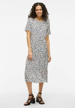 Blommig midikjol med korta ärmar, med en vit bakgrund och blommiga mönster i blått, röd och grönt; texturerad tyg med vågig nederkant.