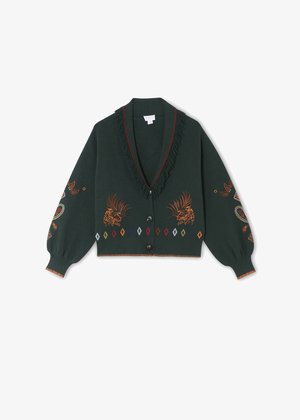 Gilet vert avec un col à franges, fermeture à boutons, et des motifs brodés colorés, incluant des animaux et des motifs géométriques.