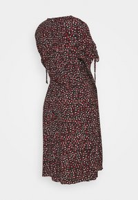 Robe noire à manches longues avec un petit imprimé floral rouge et blanc, manches froncées avec liens, et taille froncée, vue de dos.