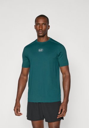 Teal short-sleeve athletic shirt with a round neckline, EA7 logo on the chest, and smooth, lightweight fabric. Suitable for active wear.