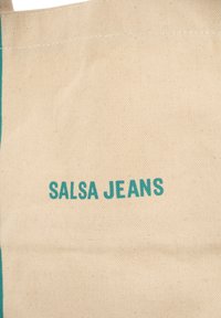 Borsa in tela color beige chiaro con testo turchese che recita "SALSA JEANS." Il tessuto è texturizzato, con un design pulito e senza ulteriori motivi.