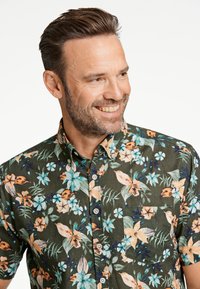 Camicia a maniche corte con un motivo floreale verde scuro, con fiori arancio e blu, taschino sul petto e design con bottoni.