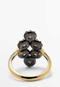 Bague noire brillante avec des éléments arrondis regroupés en haut, ornée de petites pierres précieuses claires ; anneau de couleur or.