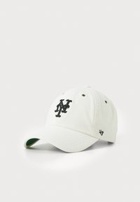 Valge korduroy beanie, millel on must tikandiga logo. Sellel on kõveräni ja õhutusaugud, detailiks roheline aluspind.